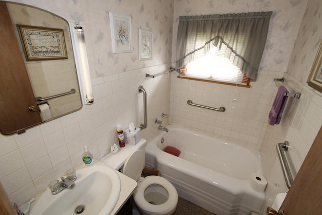 bathroom featuring a bath, tile walls, toilet, and sink