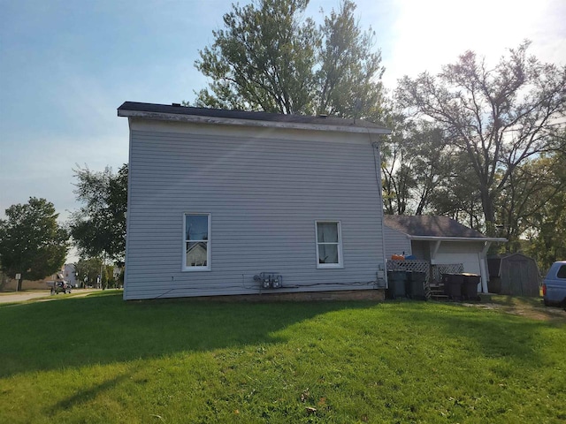 rear view of house with a yard and a shed