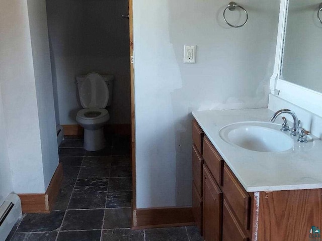 bathroom featuring baseboard heating, vanity, and toilet