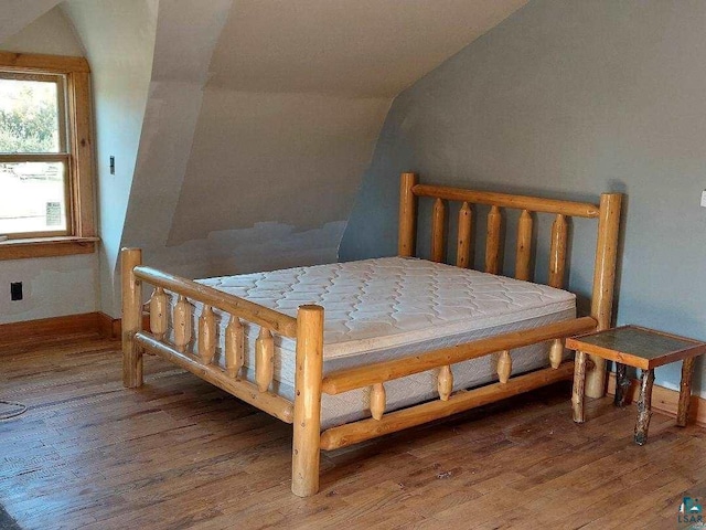 bedroom with lofted ceiling and hardwood / wood-style floors