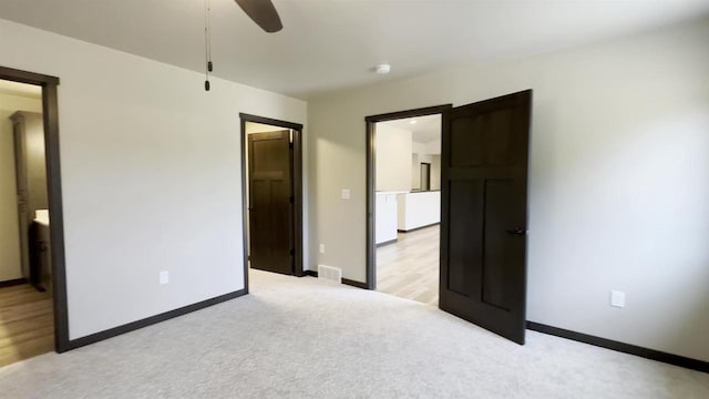 unfurnished bedroom with baseboards, light carpet, visible vents, and ceiling fan