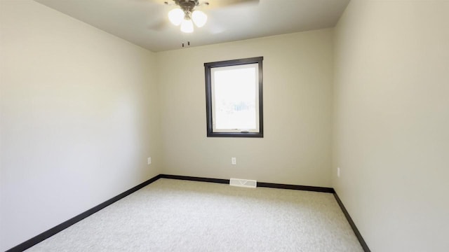 unfurnished room featuring visible vents, baseboards, light carpet, and ceiling fan