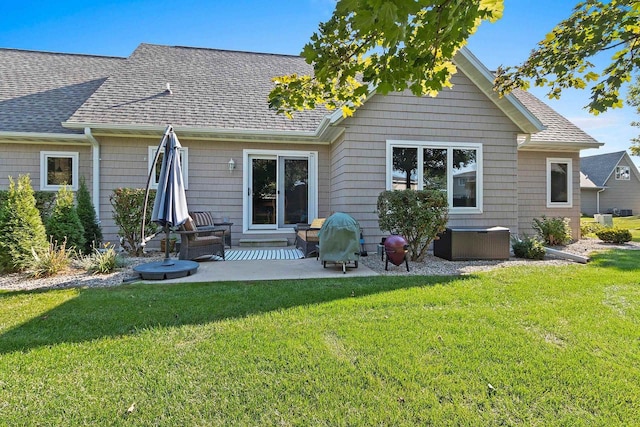 rear view of house featuring a lawn and a patio