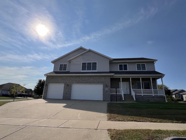 view of front property featuring a porch, a garage, and a front yard