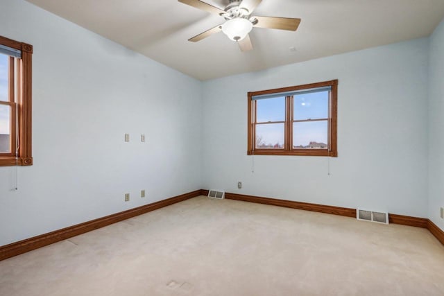 carpeted spare room with plenty of natural light and ceiling fan