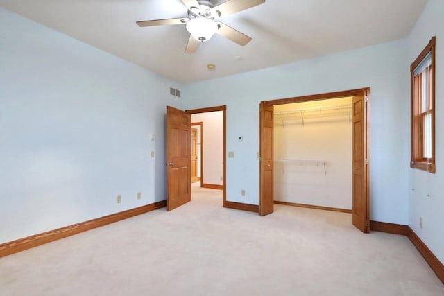 unfurnished bedroom with ceiling fan, light carpet, and a closet