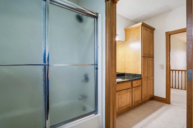 bathroom with tile patterned flooring, vanity, and bath / shower combo with glass door