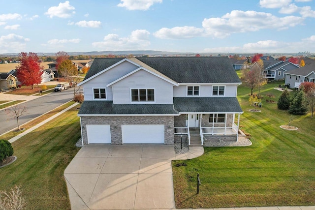 view of front of property featuring a garage, covered porch, and a front lawn