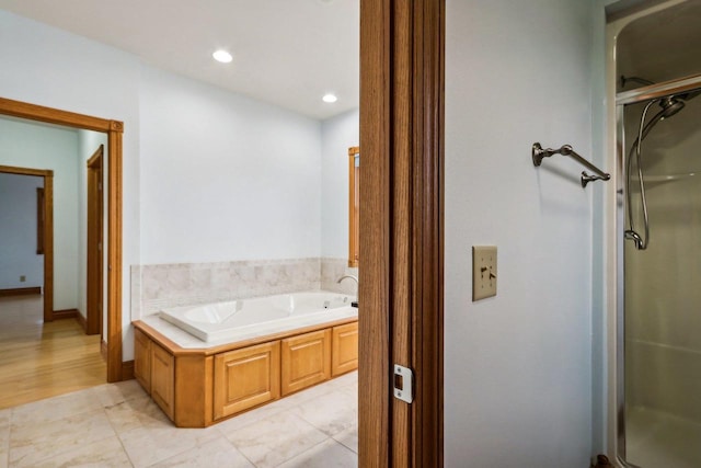 bathroom with tile patterned flooring and separate shower and tub