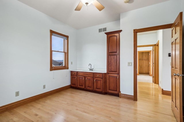 unfurnished bedroom featuring ceiling fan, light hardwood / wood-style flooring, and sink