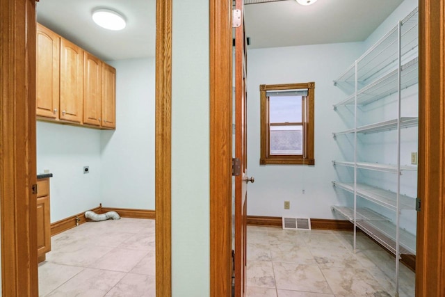 laundry area featuring cabinets, light tile patterned floors, and electric dryer hookup