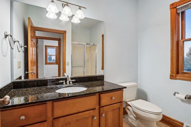 bathroom with an enclosed shower, vanity, and toilet