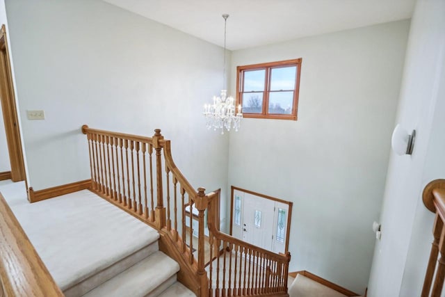 staircase with an inviting chandelier