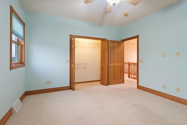 unfurnished bedroom featuring ceiling fan, light carpet, and a closet