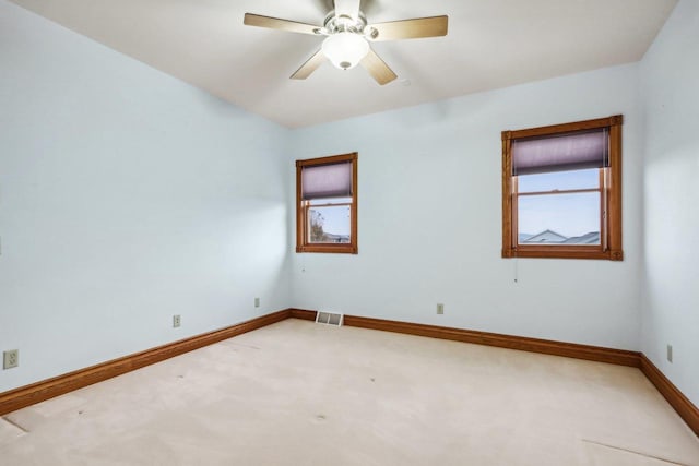 unfurnished room with ceiling fan and carpet