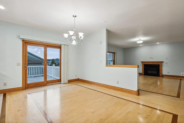 unfurnished room featuring hardwood / wood-style flooring and a notable chandelier