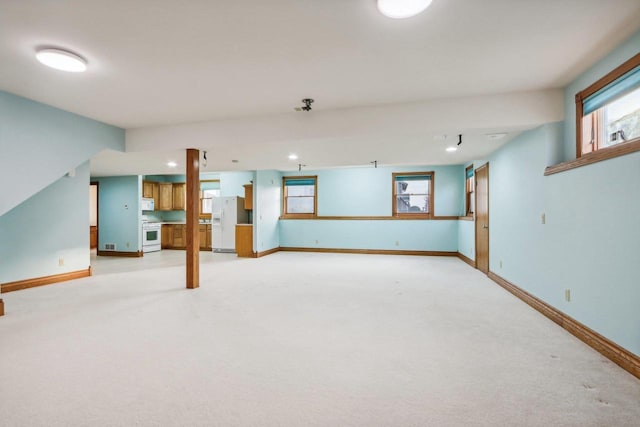 basement featuring light colored carpet and white refrigerator with ice dispenser