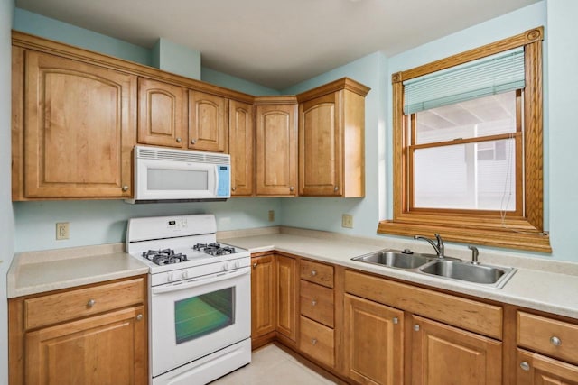 kitchen with sink, light tile patterned flooring, and white appliances