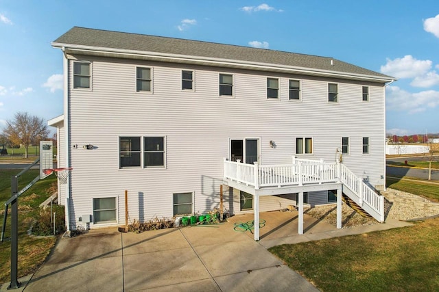 back of house featuring a wooden deck and a patio