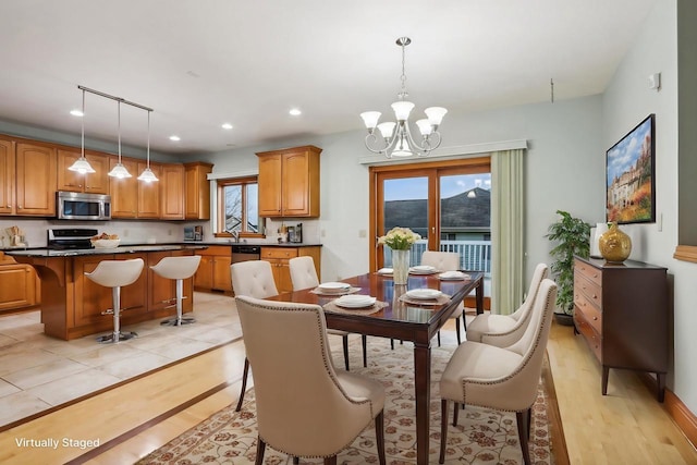 dining area featuring a chandelier, light wood-type flooring, and rail lighting