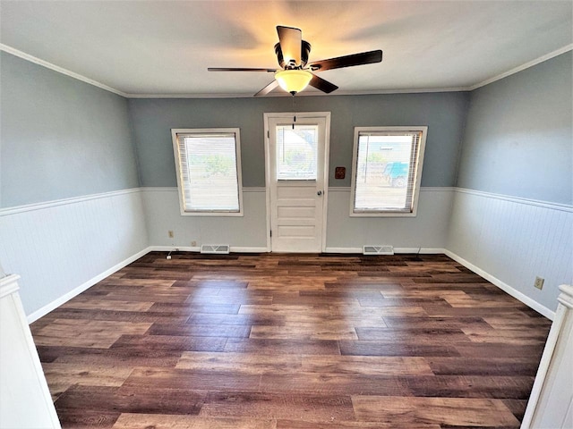 interior space featuring ceiling fan, ornamental molding, and dark wood-type flooring