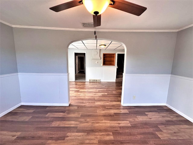 spare room featuring ornamental molding and dark hardwood / wood-style floors