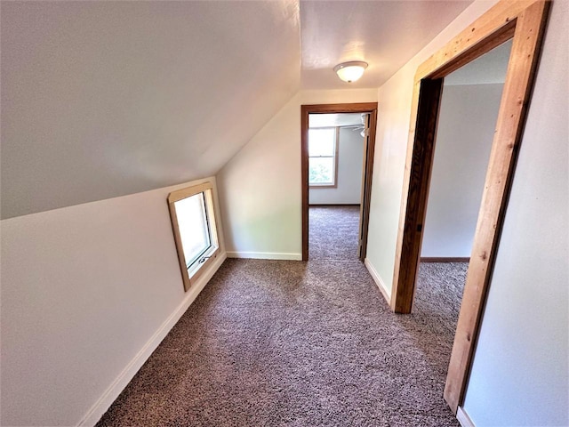 bonus room featuring vaulted ceiling and dark carpet