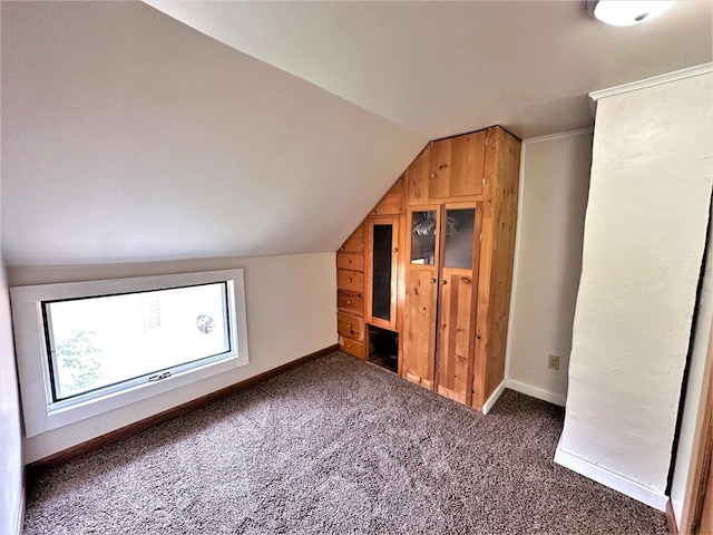 bonus room featuring lofted ceiling and dark colored carpet