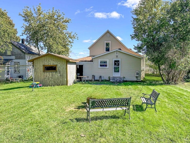 back of property featuring a yard and a shed