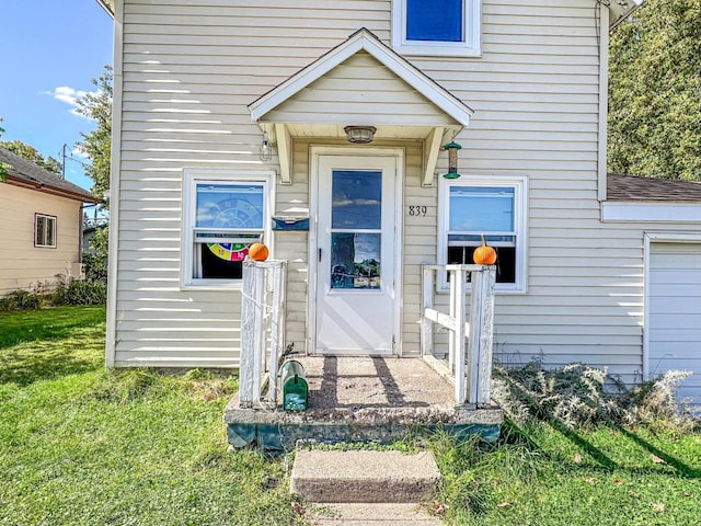 entrance to property with a lawn