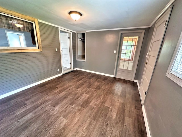 foyer entrance with ornamental molding and dark hardwood / wood-style floors