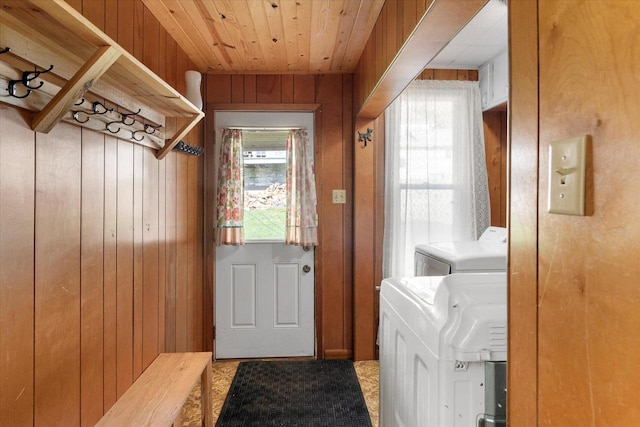 laundry room with wood ceiling, separate washer and dryer, and wooden walls