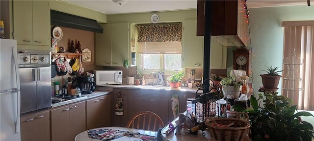 kitchen featuring green cabinets, sink, and white appliances