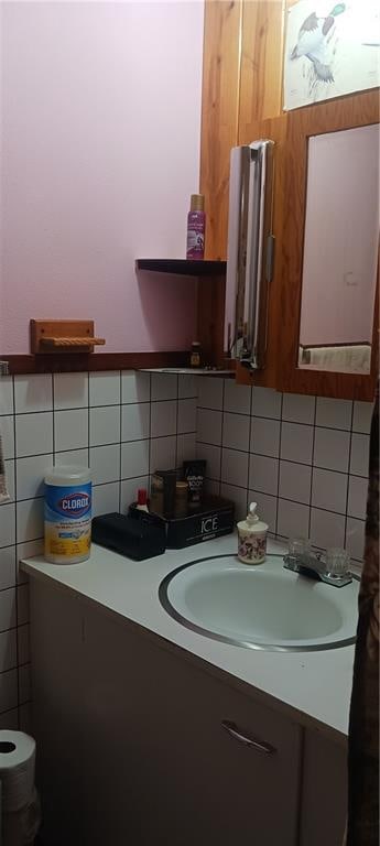 bathroom featuring vanity and backsplash