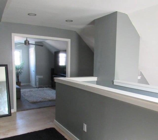 hallway with lofted ceiling and hardwood / wood-style floors