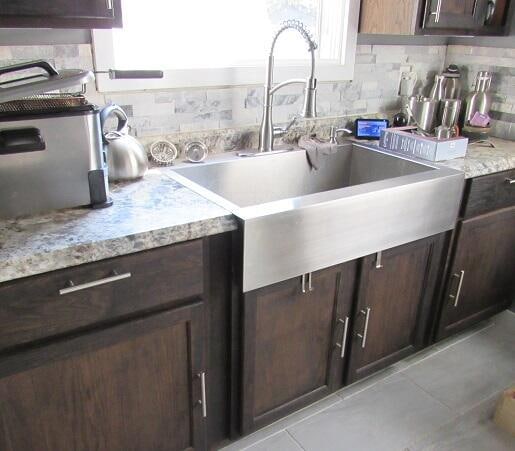 kitchen with dark brown cabinets, sink, and tasteful backsplash