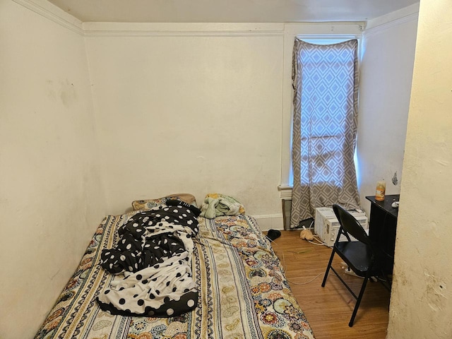 bedroom with ornamental molding and hardwood / wood-style flooring