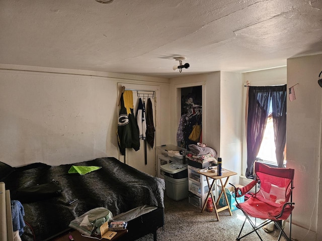 bedroom with a closet, carpet, and a textured ceiling