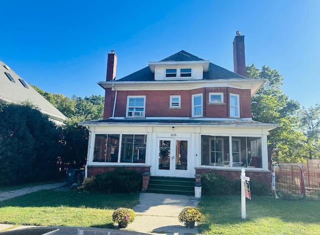 view of front of house featuring a front lawn and a sunroom