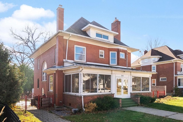 view of front of house with a sunroom and central AC