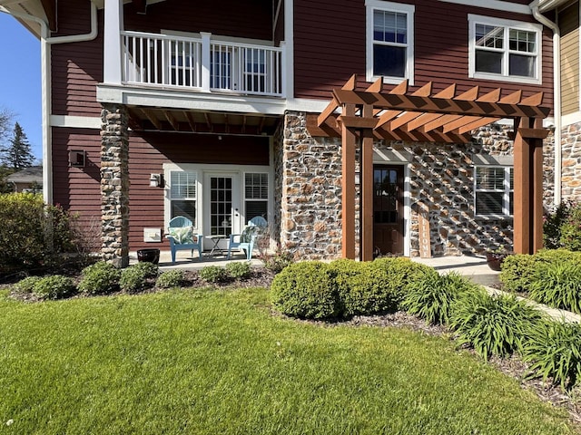 exterior space featuring a front yard, a balcony, a pergola, and a patio area