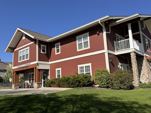 rear view of house with a balcony and a yard