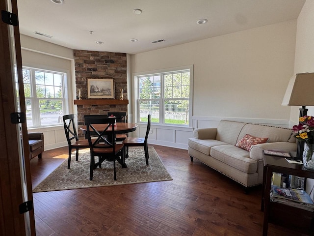 dining space with a fireplace, dark hardwood / wood-style flooring, and plenty of natural light