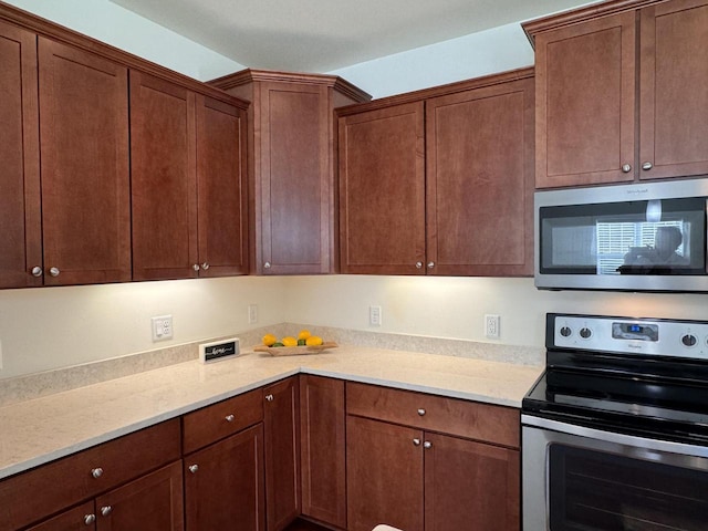 kitchen featuring light stone countertops and stainless steel appliances