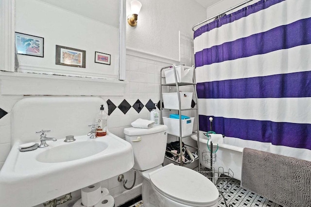 bathroom featuring sink, curtained shower, tile patterned floors, tile walls, and toilet