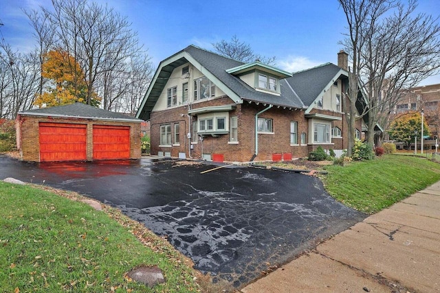 view of front facade featuring a front yard, an outdoor structure, and a garage