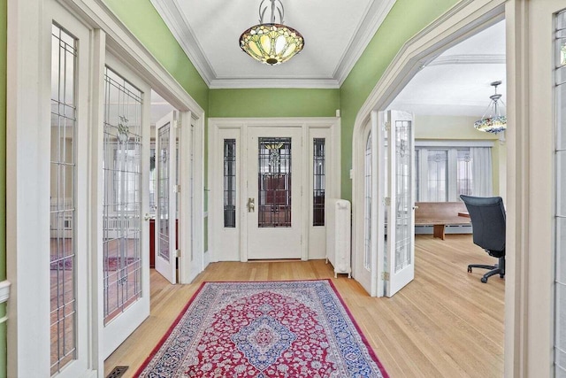 entrance foyer with wood-type flooring, radiator, and crown molding