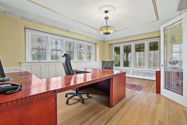 office with ornamental molding, radiator, and light hardwood / wood-style flooring