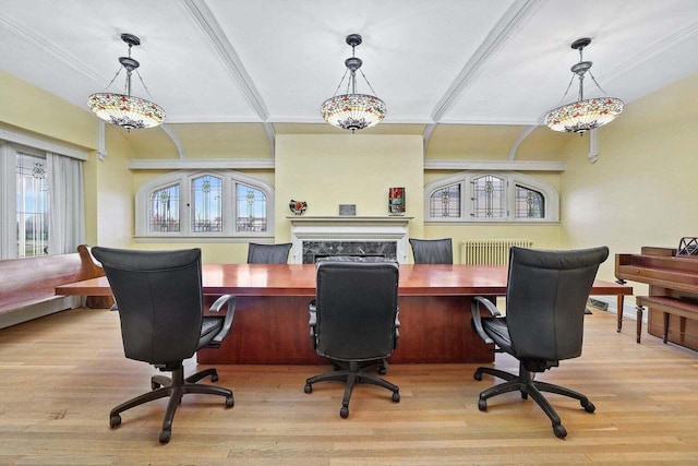 office area featuring a premium fireplace, radiator, light hardwood / wood-style floors, and ornamental molding