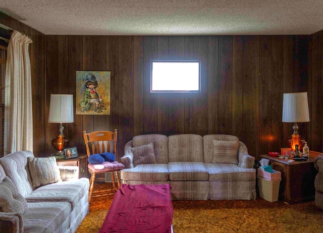 living room with a textured ceiling, wood walls, and dark colored carpet